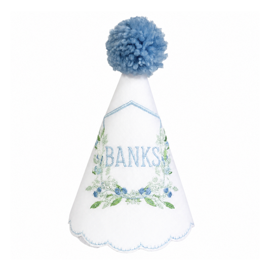 Berry Crest monogram linen first birthday party hat with blue crest embroidery and blue pom pom