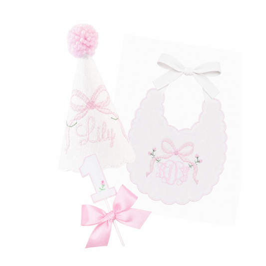 Bows and Blooms 3-piece first birthday cake smash set with embroidered party hat, birthday bib, and rosebud bow cake topper