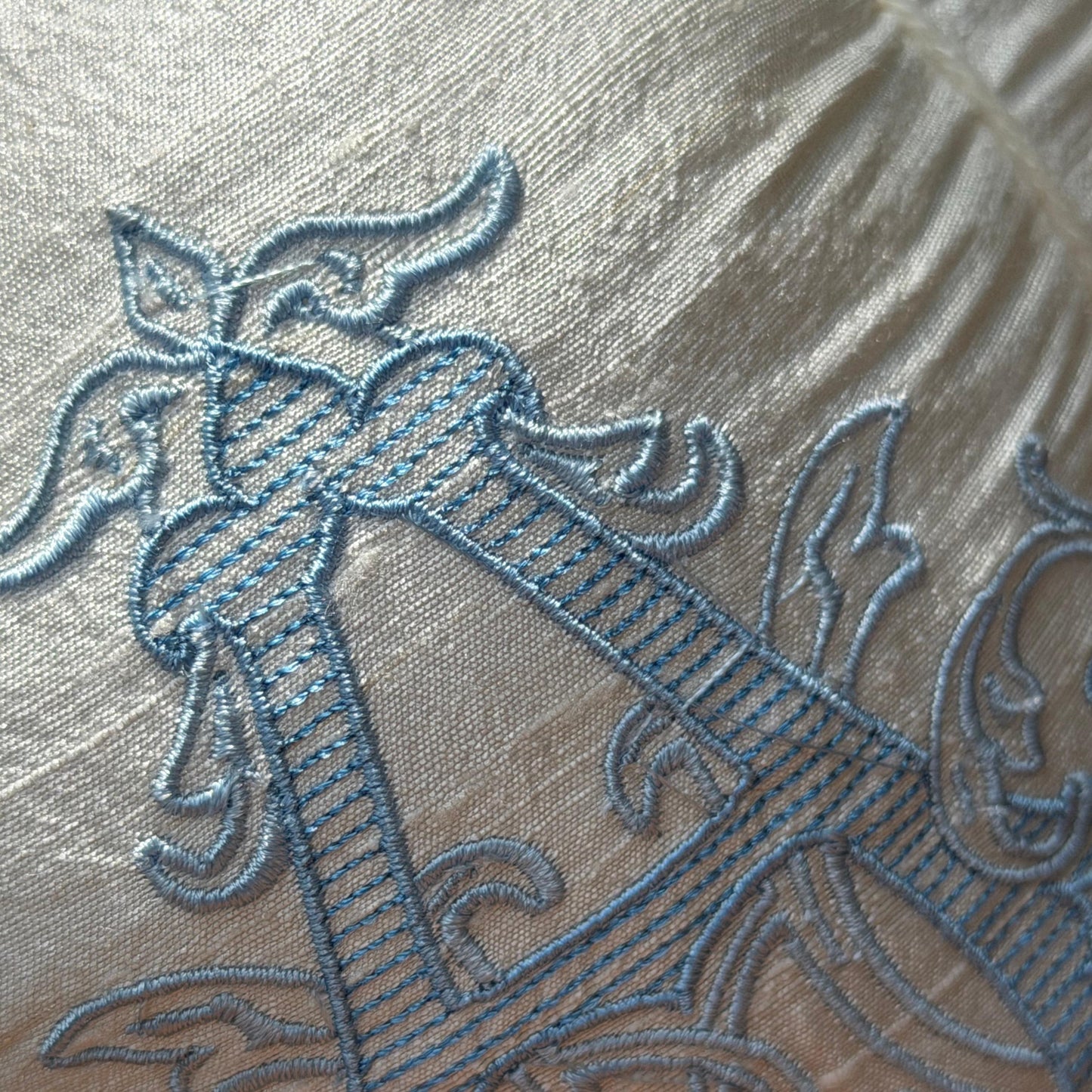 Close-up of layered blue monogram embroidery on the Chateau ivory silk pumpkin