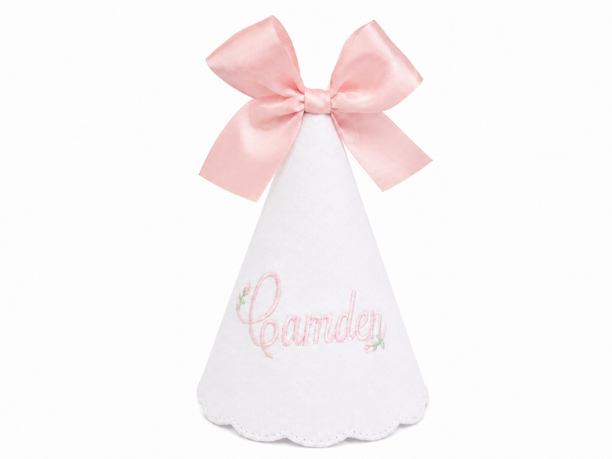 Personalized Rosebud linen first birthday party hat with pink floral embroidery, embroidered name, and bow topper