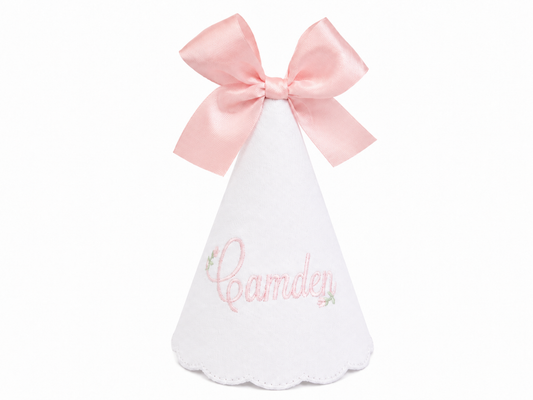 Personalized Rosebud linen first birthday party hat with pink floral embroidery, embroidered name, and bow topper