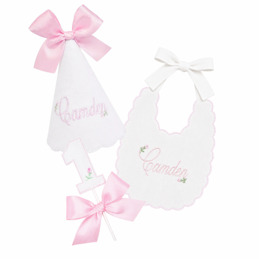 Rosebud 3-piece first birthday cake smash set with personalized rosebud party hat, name bib, and rosebud bow cake topper